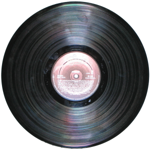 LP, showing its central spindle hole and label surrounded by the grooved area. Five separate "tracks" are visible, but all are parts of one continuous spiral groove. Via Wikipedia.