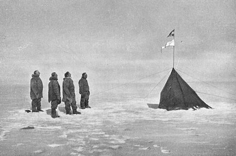 Roald Amundsen, Helmer Hanssen, Sverre Hassel and Oscar Wisting (l–r) at "Polheim", the tent was erected at the South Pole on 16 December 1911. The top flag is the Flag of Norway; the bottom is marked "Fram". Photograph by Olav Bjaaland. 