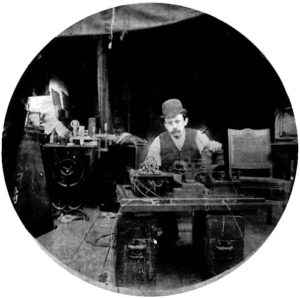 Charles Kayser of the Edison lab seated behind the Kinetograph. Portability was not among the camera's virtues. Via Wikipedia.